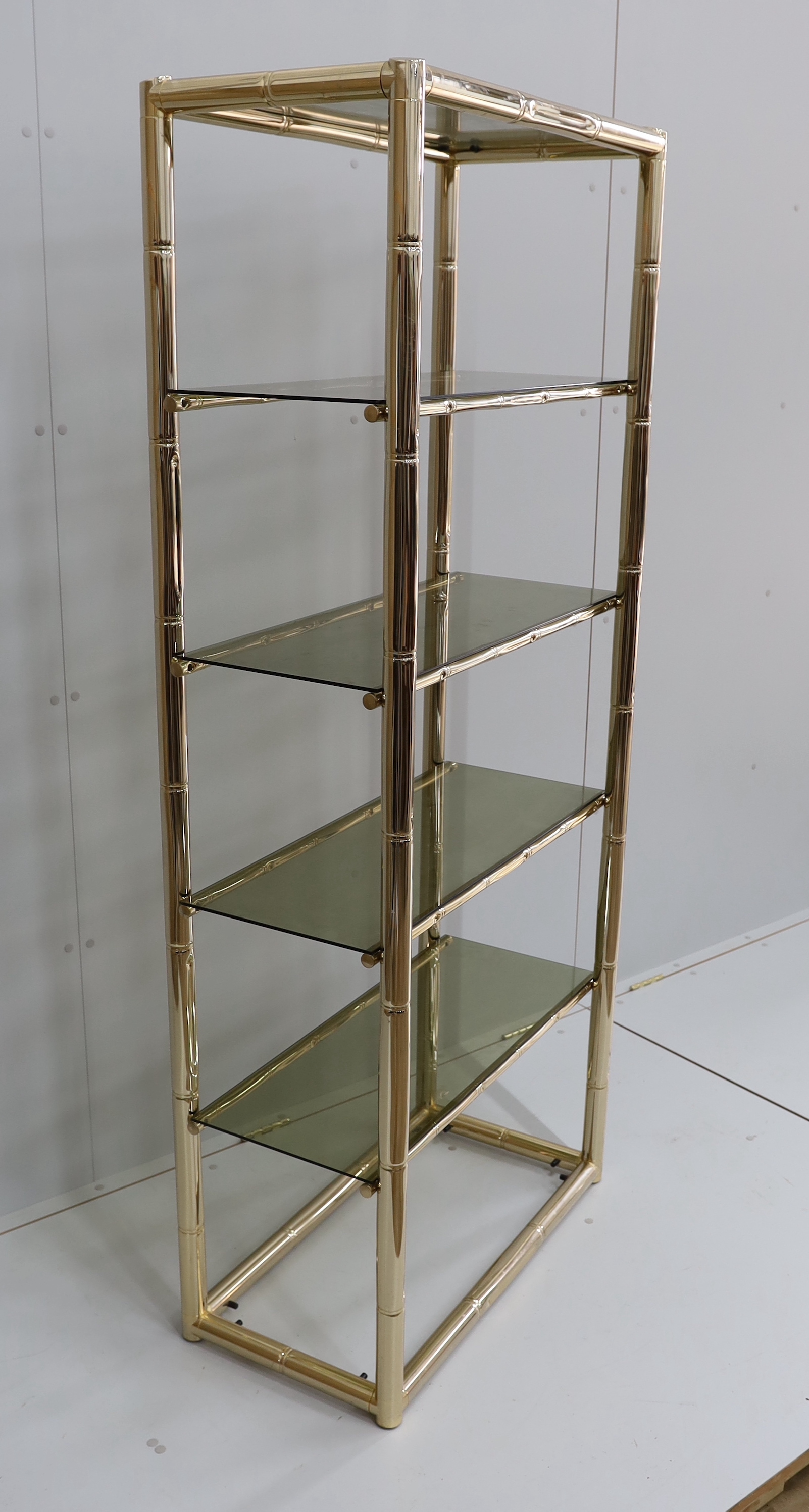 A Maison Jansen style faux bamboo brass and smoked glass five tier shelf unit, width 76cm, depth 39cm, height 180cm